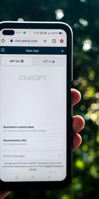 A person uses ChatGPT on a smartphone outdoors, showcasing technology in daily life.