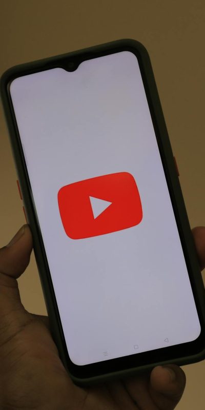 Close-up of a smartphone displaying the YouTube app logo on the screen.